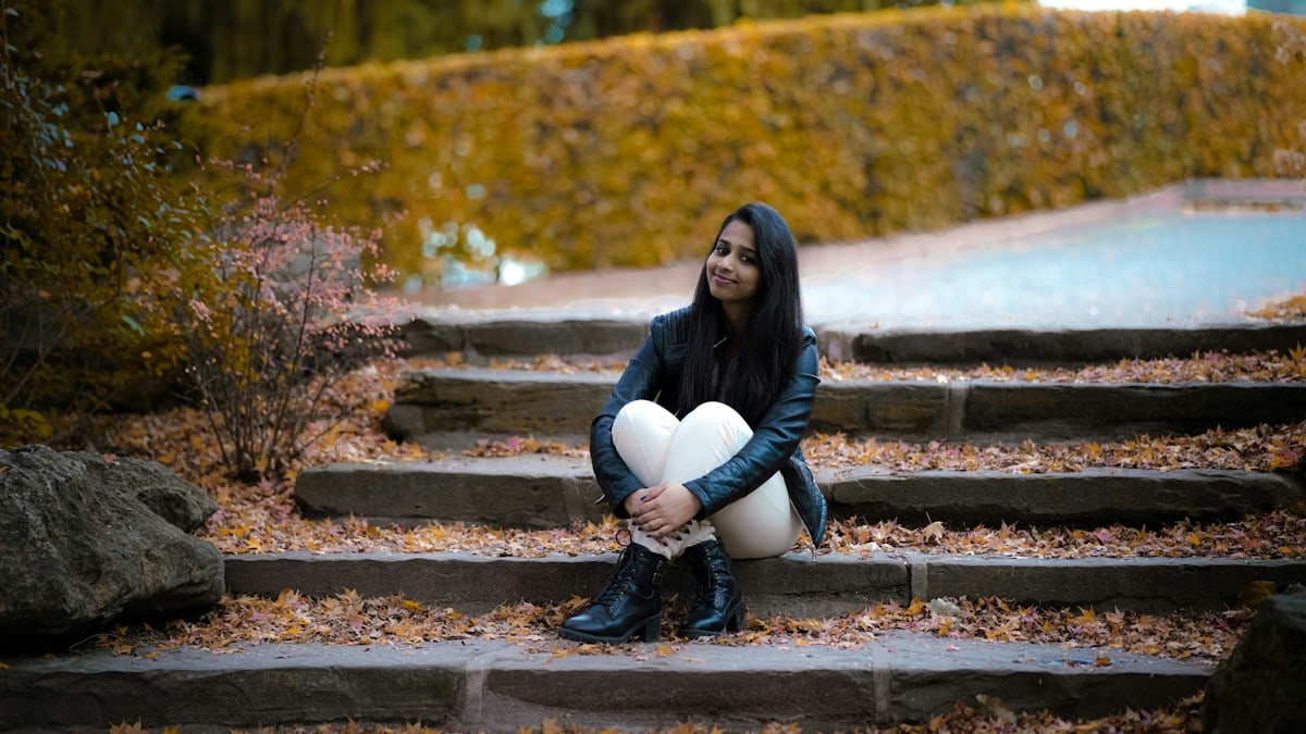 a woman sitting on steps holding a heart shaped pillow